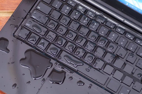 Vista acima do laptop com água cair dano líquido molhado e derramamento no teclado, conceito de acidente — Fotografia de Stock