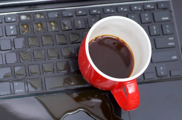 Acima da vista da gota de café e uma xícara vermelha de café sobre o laptop, danos líquido molhado e derramamento no teclado, conceito de acidente — Fotografia de Stock