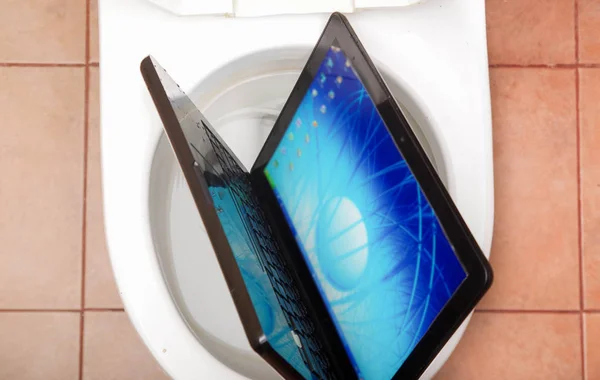 Boven uitzicht van zeer slordig persoon vergat de computer in het toilet — Stockfoto