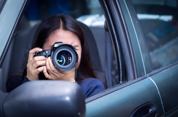 Junge Frau, die mit ihrer Kamera im Auto pirscht und fotografiert — Stockfoto