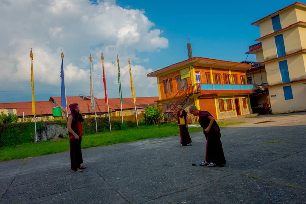 ПОХАРА, НЕПАЛЬ - ОКТЯБРЬ 06 2017: Неопознанные буддийские монахи-подростки наслаждаются свободным временем в патио на открытом воздухе в прекрасный день в поселении беженцев Таши в Похаре, Непал — стоковое фото