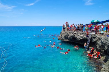 Batı görünümü, Kolombiya - 03 Ekim 2017: bir kayadan atlama ve muhteşem mavi su, Johnny Cay San güneşli bir günde sırasında San Andres adadan güzel manzarayı Tanımlanamayan kişi