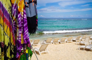 Bazı renkli kumaşlar ve bazı beyaz plastik sandalyeler kum San Andres Beach, Kolombiya yakın çekim