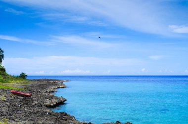 San Andres, Kolombiya - 21 Ekim 2017: Kayalar ve masmavi bir deniz, San Andres adasında San Andres, Kolombiya güneşli bir günde bir gorgeos kırmızı botla güzel manzarasına