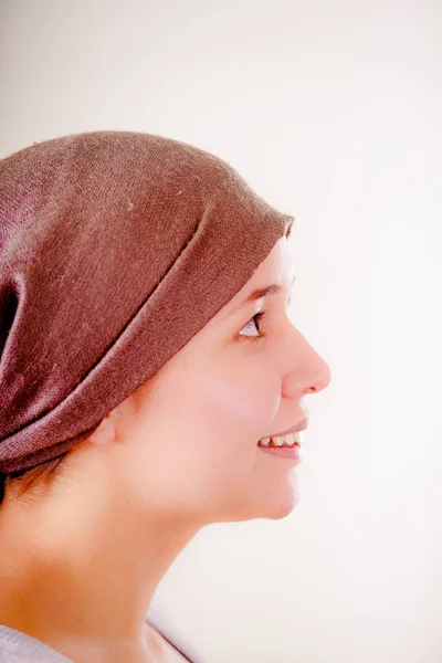 Retrato de una mujer con cáncer que usa pañuelo en la cabeza en un fondo borroso, vista lateral —  Fotos de Stock