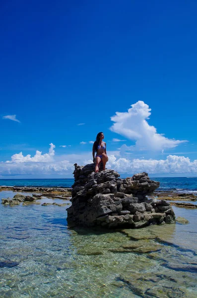JOHNNY CAY, COLOMBIA - 21 de octubre de 2017: Mujer no identificada disfrutando del hermoso día soleado sobre una roca en la costa de la isla Johnny Cay — Foto de Stock