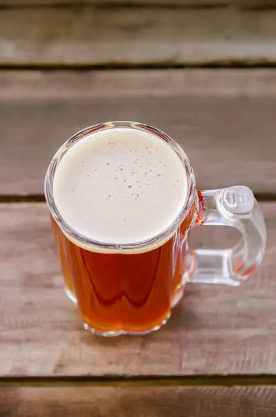 Boven weergave van glas bier met een houten achtergrond — Stockfoto