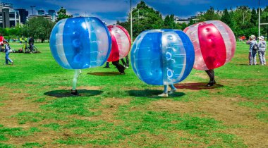 Quito, Ekvator - 28 Kasım 2017: Açık kimliği belirsiz gençler maç sırasında dev şişme kırmızı ve mavi top Carolina Park içinde şehir Festivali sırasında görülmektedir