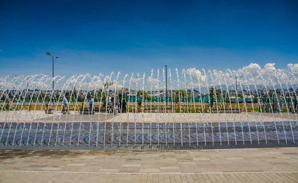 QUITO, ECUADOR - 27 DE NOVIEMBRE DE 2017: Personas no identificadas disfrutando de la hermosa vista al aire libre del nuevo bulevar en la calle principal de la avenida Amazonas con una estructura de entretenimiento acuático en la ciudad de Quito —  Fotos de Stock