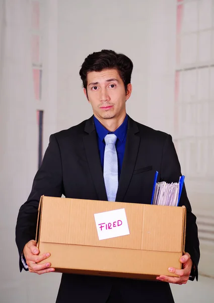 Primer plano de un hombre triste sosteniendo una caja después de ser despedido de su trabajo en un fondo borroso —  Fotos de Stock