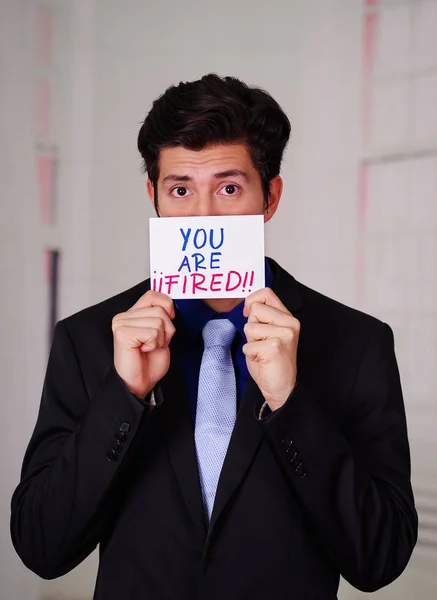 Business man hold paper youre fired text on it, in a blurred background — Stock Photo, Image