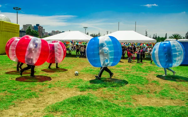 QUITO, ECUADOR - 28 DE NOVIEMBRE DE 2017: Jóvenes no identificados jugando al fútbol mientras están dentro de gigantescas bolas inflables azules y rojas en el Parque Carolina durante un festival en la ciudad de Quito — Foto de Stock