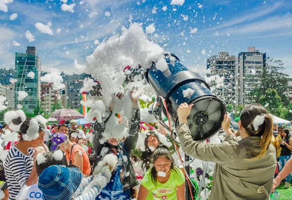 QUITO, ECUADOR-NOVEMBRE, 28, 2017: Bella e divertente veduta della donna con la macchina della schiuma e il gruppo di bambini che si godono una festa in schiuma al festival di Quito — Foto Stock
