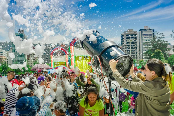 QUITO, ÉQUATEUR - 28 NOVEMBRE 2017 : Belle et amusante vue de la femme avec machine à mousse et groupe d'enfants profitant et dansant lors d'une fête en mousse au festival Quito — Photo
