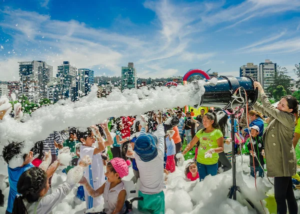 QUITO, ECUADOR-NOVEMBRE, 28, 2017: Bella e divertente veduta della donna con la macchina della schiuma e il gruppo di bambini che si divertono e ballano a una festa in schiuma al festival di Quito — Foto Stock