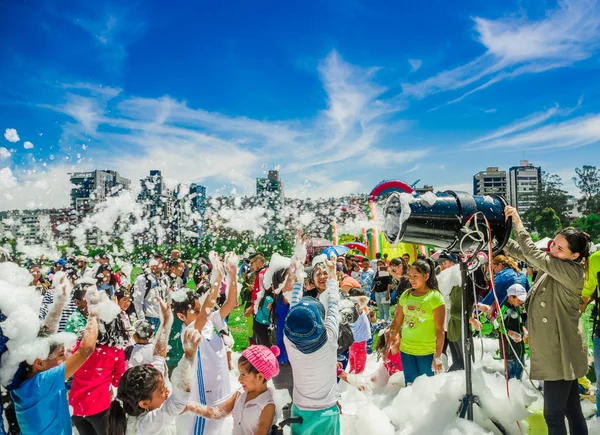 基多, 厄瓜多尔-11月, 28, 2017: 妇女的室外观点与泡沫机器和小组儿童享用和跳舞在一个泡沫党在基多节日 — 图库照片