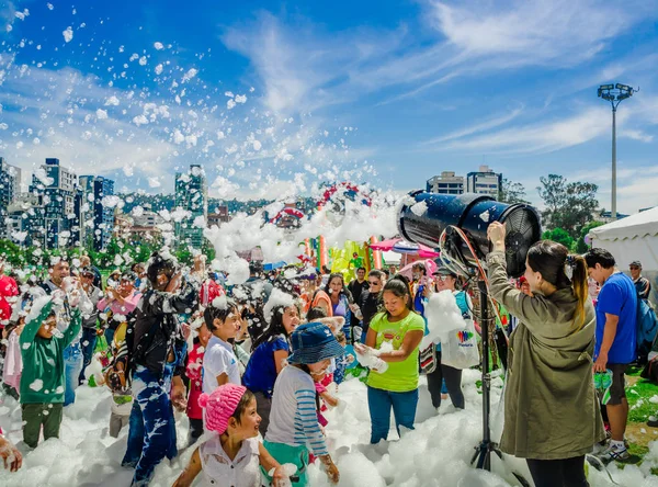 QUITO, ECUADOR- NOVEMBER, 28, 2017: Outdoor view of woman with foam machine and unidentified people enjoying and dancing at a foam party at Quito festival — Stock Photo, Image