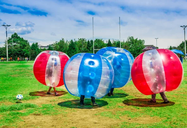 QUITO, ECUADOR - 28 DE NOVIEMBRE DE 2017: Jóvenes jugando al fútbol mientras están dentro de pelotas inflables gigantes en el Parque Carolina durante un festival — Foto de Stock