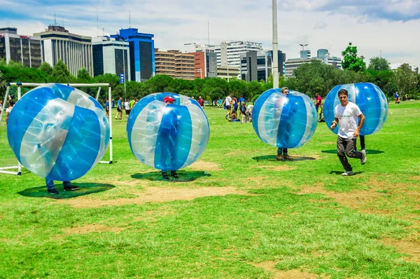 QUITO, ECUADOR - 28 DE NOVIEMBRE DE 2017: Jóvenes jugando al fútbol mientras están dentro de una bola inflable gigante en el Parque Carolina durante un festival — Foto de Stock