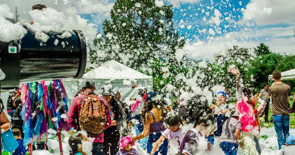 QUITO, ECUADOR- NOVEMBRE, 28, 2017: Veduta esterna dell'uomo che spara schiuma con una macchina e persone non identificate che si divertono e ballano a una festa in schiuma al festival di Quito — Foto Stock