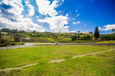 Kırsal bir yol güzel manzarasına Otavalo, güzel bir mavi gökyüzü ile bazı yeşil çim eteklerinde