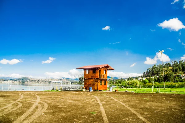 Hermosa vista al aire libre de una construcción de cabaña de madera en la frontera del lago San Pablo en medio del valle en un hermoso día con cielo azul y algunas nubes — Foto de Stock