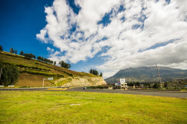 Hermosa vista de un camino rural en las afueras de Otavalo, en un hermoso cielo azul con un poco de hierba verde — Foto de Stock