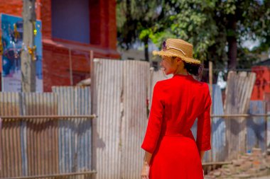 Katmandu, Nepal 15 Ekim 2017: Durbar Meydanı yakınındaki eski hindu beautidul güneşli bir gün içinde fotoğraf için poz kırmızı bir elbise ve şapka ile güneş gözlüğü takmış kafasına, belirsiz Nepal kadın 
