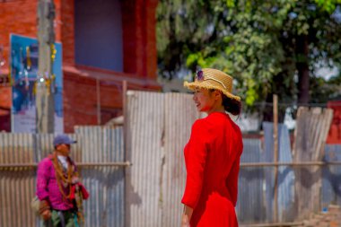 Katmandu, Nepal 15 Ekim 2017: Durbar Meydanı yakınındaki eski hindu beautidul güneşli bir gün içinde fotoğraf için poz kırmızı bir elbise ve şapka ile güneş gözlüğü takmış kafasına, belirsiz Nepal kadın 