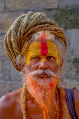 Katmandu, Nepal 15 Ekim 2017: Shaiva portre sadhu turuncu sakallı, Nepal boyalı yüzü ile Pashupatinath Tapınağı kutsal adam