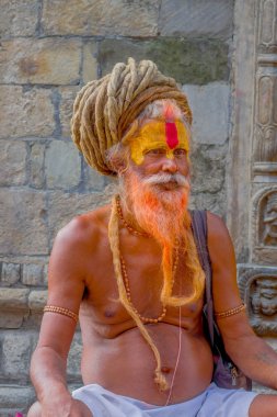Katmandu, Nepal 15 Ekim 2017: Shaiva sadhu turuncu sakallı, Nepal boyalı yüzü ile Pashupatinath Tapınağı kutsal adam, kapat