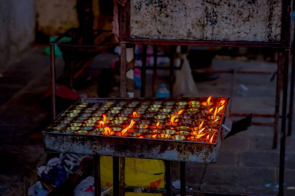 Brennende Kerzen innerhalb eines metallischen Tabletts im Tempel. kathmandu, nepal, asien — Stockfoto