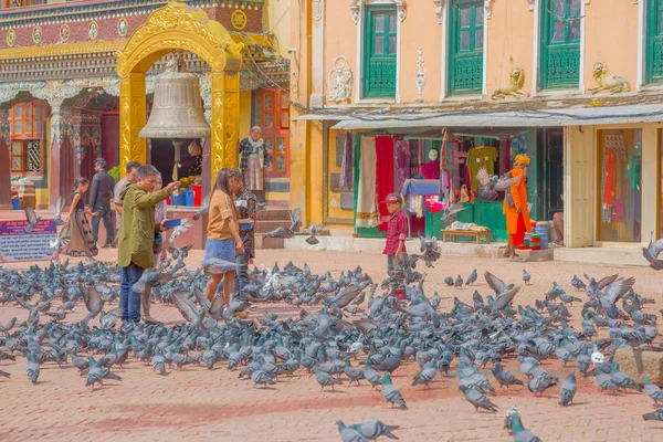 KATHMANDU, NEPAL OCTUBRE 15, 2017: Personas no identificadas caminando en la plaza que rodea a cientos de palomas frente a una enorme campana bajo una estructura de oro apedreado en Katmandú Boudhanath Stupa en — Foto de Stock