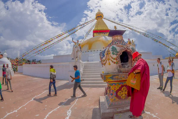 Káthmándú, Nepál 15 října 2017: Neznámých lidí, kteří jdou v přírodě nedaleko stupa Boudhanath pomník a jeho barevné vlajky v letní obloha bue v Káthmándú, Nepál — Stock fotografie