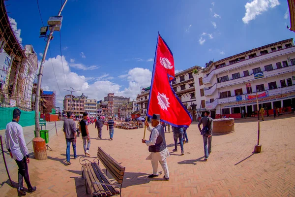 Kathmandu, Nepal 15. Oktober 2017: Unbekannte gehen durch die Straßen und ein nepalesischer Mann hält eine Fahne in den Händen auf dem Durbar-Platz in Kathmandu, der Hauptstadt Nepals, Fischaugeneffekt — Stockfoto