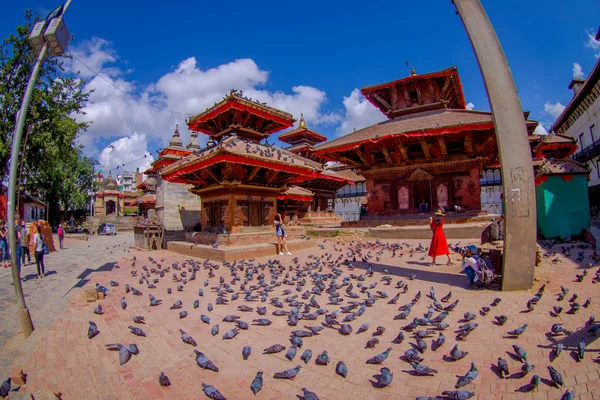 KATHMANDU, NEPAL OCTOBER 15, 2017: Unidentified people walking and taking pictures in the streets with a flock of pigeons at Durbar square near old hindu temples in Kathmandu, Nepal, before the 2015 — Stock Photo, Image