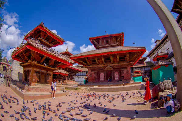 KATHMANDU, NEPAL OCTOBER 15, 2017: Unidentified people walking and taking pictures in the streets with a flock of pigeons at Durbar square near old hindu temples in Kathmandu, Nepal, before the 2015 — Stock Photo, Image