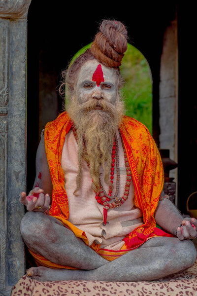 Катхманду, НЕПАЛ - 22 марта 2017 года: Крупный план Йоги Шайвы садху, сидящего в храме Пашупатинатхи в Катманду со скрещенными ногами, в Непале
