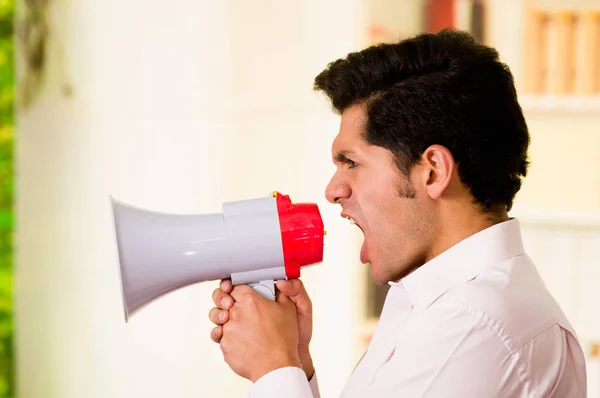 Zblízka pohledný muž křičí s megafon rozostřeného pozadí — Stock fotografie