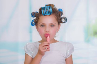 küçük kız boyama dudaklar ise saç-silindirler ve bornoz giyiyor