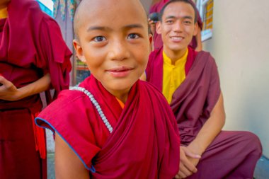 Pokhara, Nepal - 06 Ekim 2017: Tashi mülteci yerleşim Pokhara, Nepal, açık havada, arkadaşlarıyla birlikte boş vaktinizi tanımlanamayan Budist keşiş genç portresi
