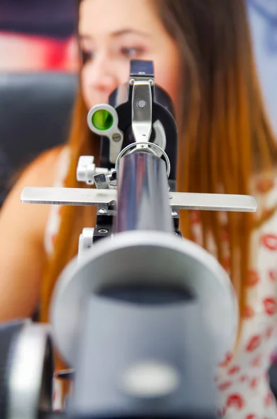 Неопознанная женщина проверяет зрение с помощью современного оборудования, проверяет зрение оптически, на размытом фоне — стоковое фото