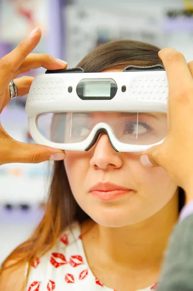 Mujer no identificada con gafas modernas para la visión por equipos modernos, examen de los ojos en óptica, en un fondo borroso —  Fotos de Stock