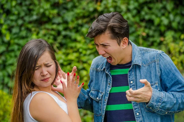 Dva boje. Mladý muž křičí mladá žena, zatímco mladá žena vypadá strach, friendzone koncept — Stock fotografie