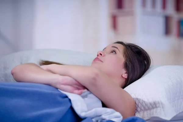Gros plan d'une jeune femme souffrant d'insomnie les bras croisés attendant de dormir — Photo