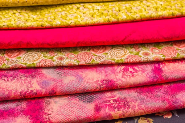 Närbild av olika tyg i olika färger, tyg väntar sy kläder och andra saker, röd, gult tyg — Stockfoto