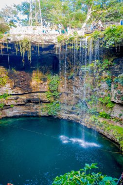 Ik-Kil Cenote near Chichen Itza, Mexico. Lovely cenote with transparent waters and hanging roots clipart