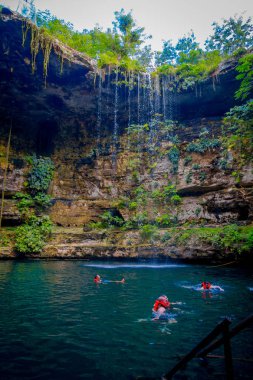Chichen Itza, Meksika - 12 Kasım 2017: IK-Kil hipotermik Chichen Itza, Meksika yakınındaki Yüzme tanımlanamayan gençler. Güzel hipotermik şeffaf turkuaz suları ve asılı kökleri ile