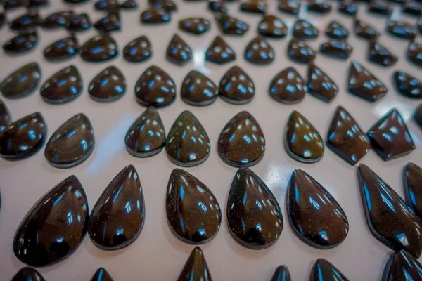 Detailní záběr z krásných a než se dostal přírodní minerální kámen - Černý obsidián drahokam z Mexika přes stůl uvnitř obchod se suvenýry — Stock fotografie