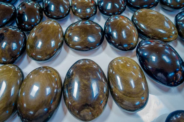 Close up of shinny natural mineral stone - black obsidian gemstone from Mexico over a table inside of a souvenir store — Stock Photo, Image